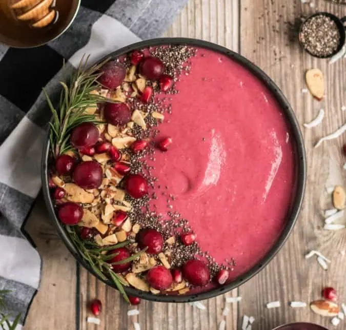Cleansing recipes - cranberry smoothie bowl topped with almonds cranberries and rosemary