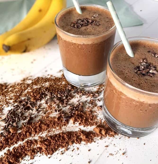 Cleansing recipes - two glasses of banana coffee smoothie with chocolate and bananas scattered around them