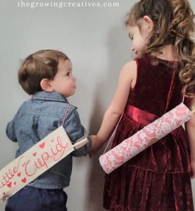 Two children holding Valentine's Day bows and arrows