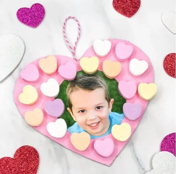 A heart shaped photo frame with a picture of a boy in it