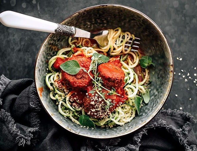 detox recipes - vegan black bean meatballs with zoodles and marinara in a bowl with a fork