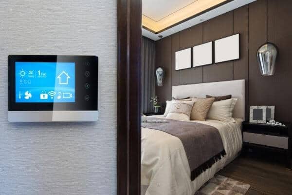 a programmable thermostat on a wall outside a bedroom