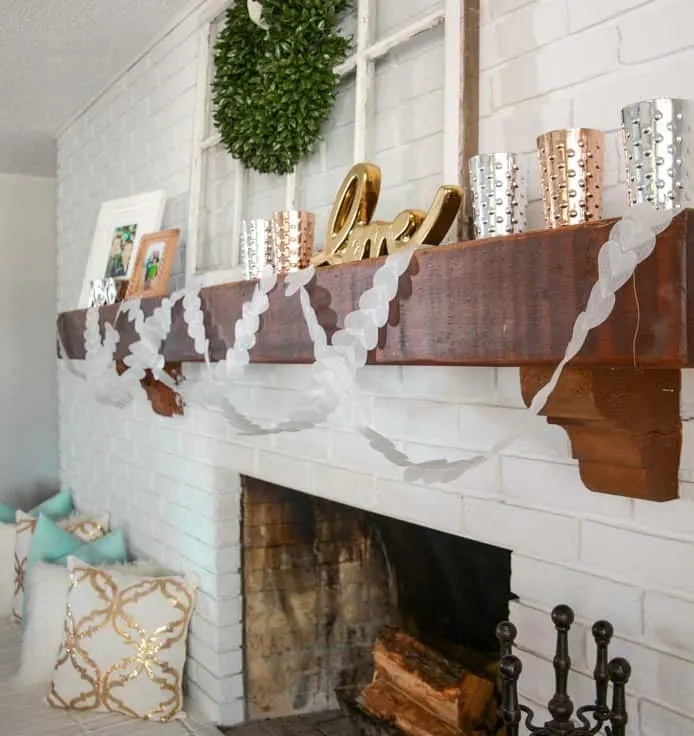 DIY Wax Paper Valentines Banner hanging from a wooden mantle