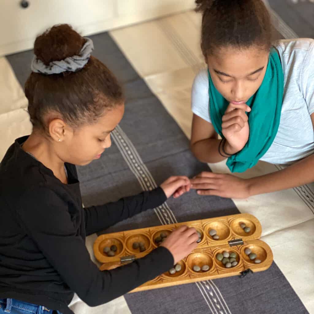 introducing games from different cultures is a great addition to unit studies. In this picture, two girls play a game from Nigeria. 
