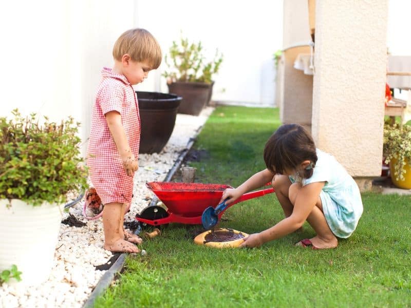 kids playing with mud in a yard