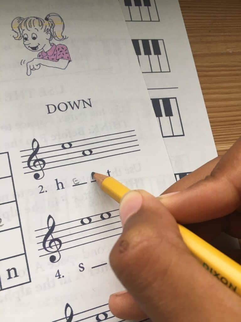 a student takes completes exercises from the Revolutionary Piano Training workbook