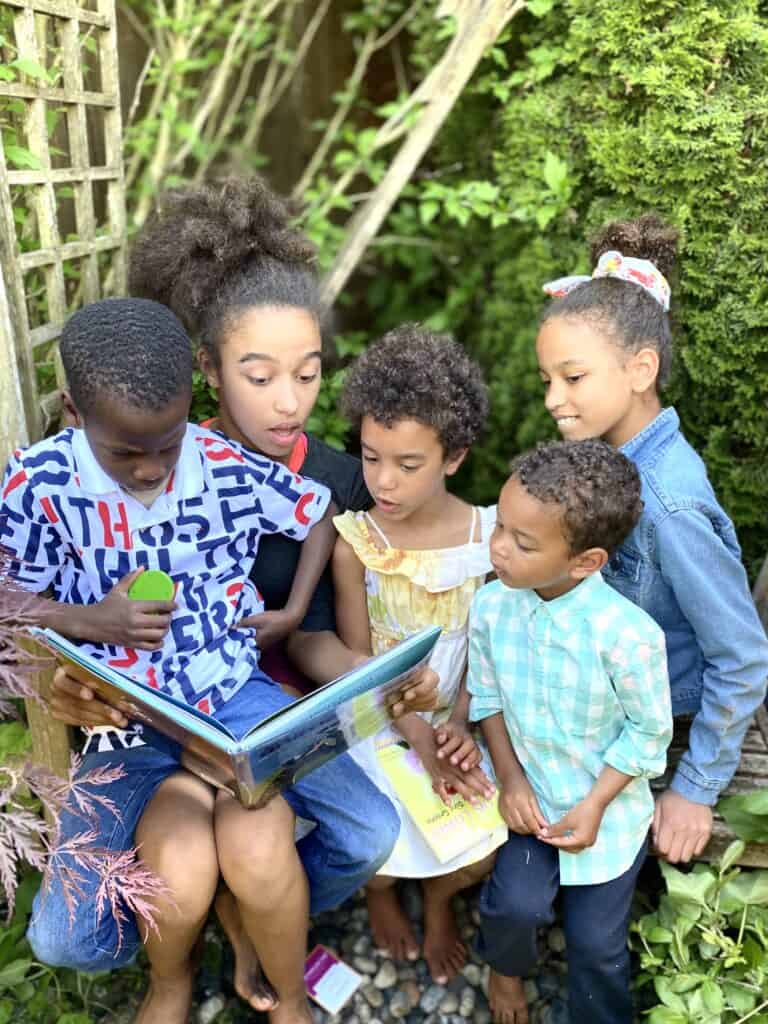 a family of kids read together outside - choosing a literature-based program that kids love  can improve the family dynamic in your homeschool