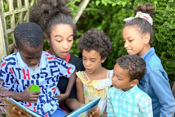 family of children read sonlight books together