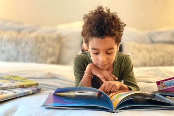 a little girl reads her schoolbooks