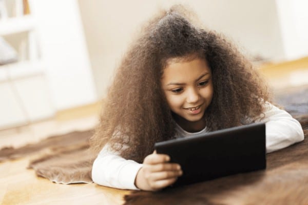 a little girl learns on a tablet