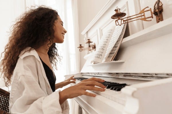 An adult woman playing piano