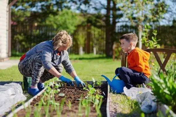 a mom and son garden in the backyard - homeschooling shouldn't be confined to the work you do in your homeschool room