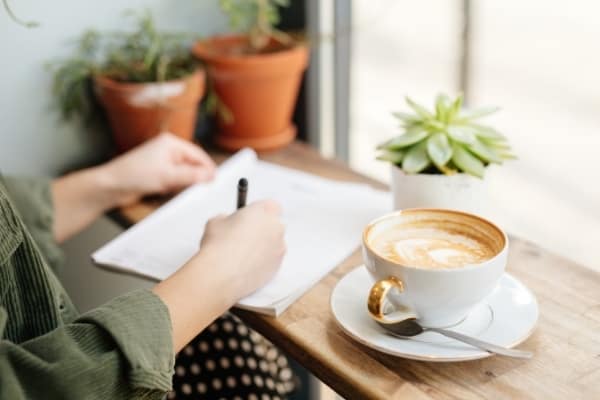 a woman plans her day while drinking a latte