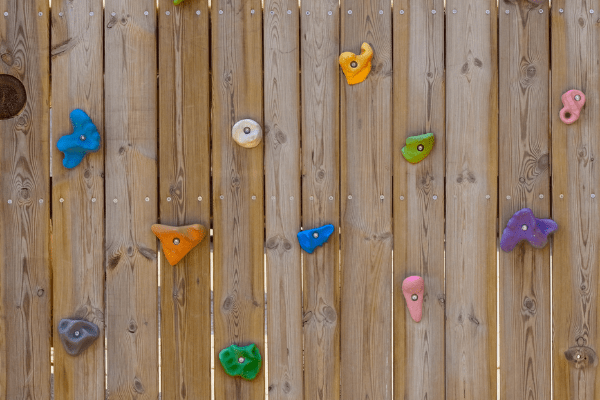 climbing holds affixed to a fence or wall make a DIY climbing wall in the backyard