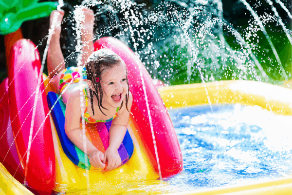 little girl playing in a DIY backyard splashpad - an easy DIY project for a kid-friendly backyard