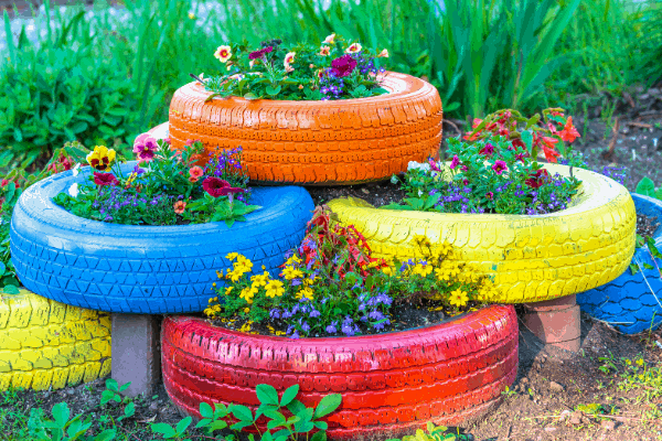 colorful tires can be used to grow plants in a backyard