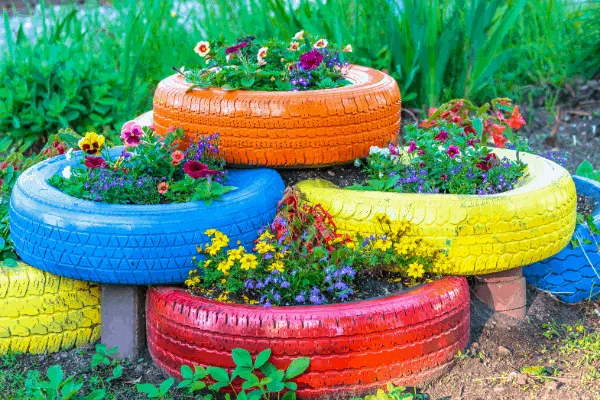 colorful tires can be used to grow plants in a backyard