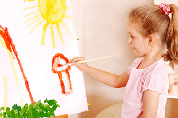 Child painting with an easel and brush