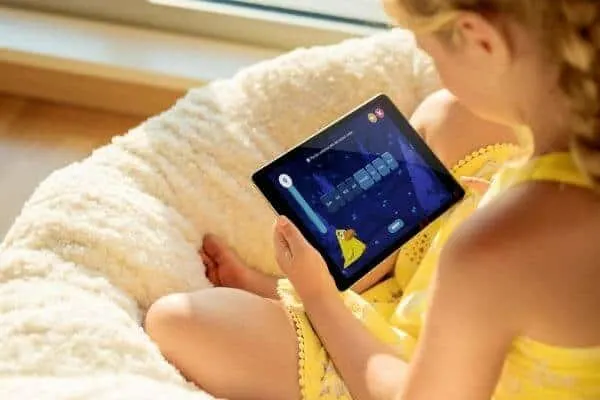 a little girl uses Night Zookeeper on a tablet