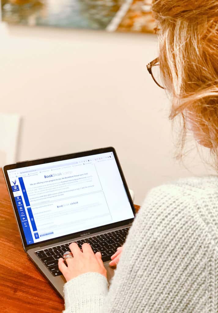 BookShark Virtual makes homeschool reporting online easy | a woman uses a laptop