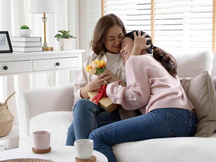 The best gifts to give to parents | a mother hugs her daughter while holding a gift
