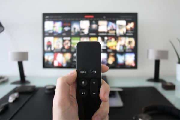 gifts that keep giving | you can never have too many options when it comes to streaming services | a hand holds a remote in front of a TV