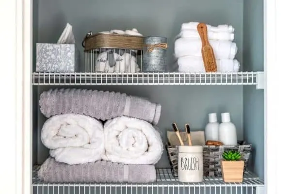 how to start organizing a messy house | bathroom shelves with towels and toiletries