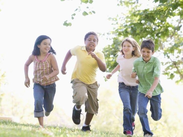 a group of kids run through a field