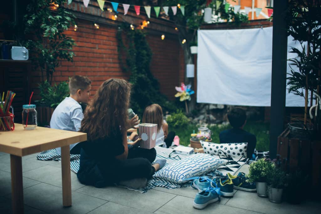 people watching a movie in their backyard