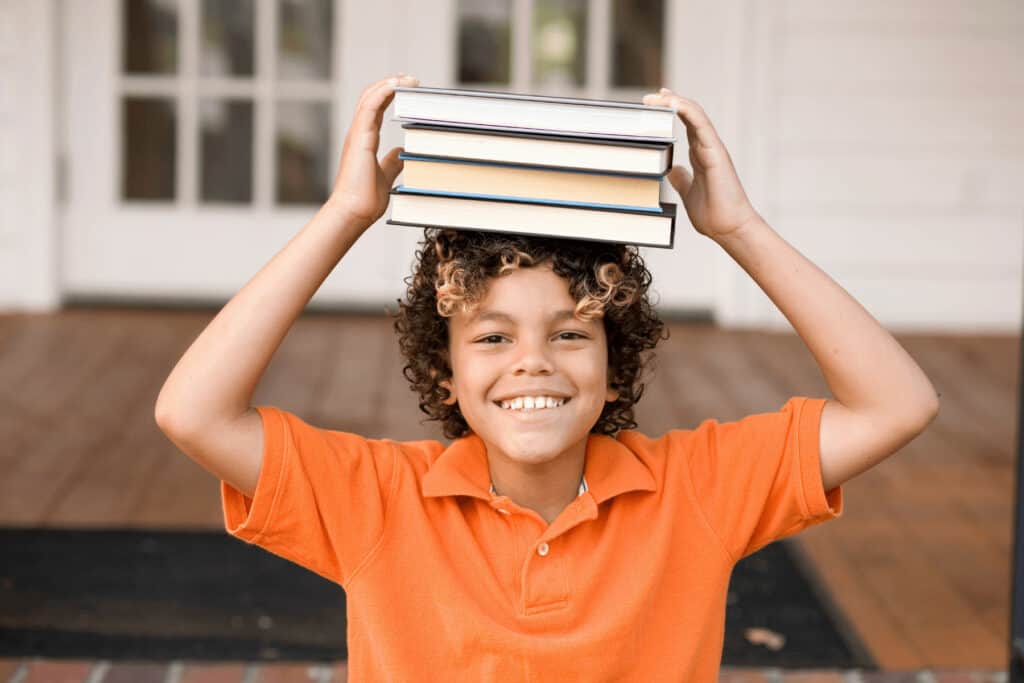 a boy with a stack of books