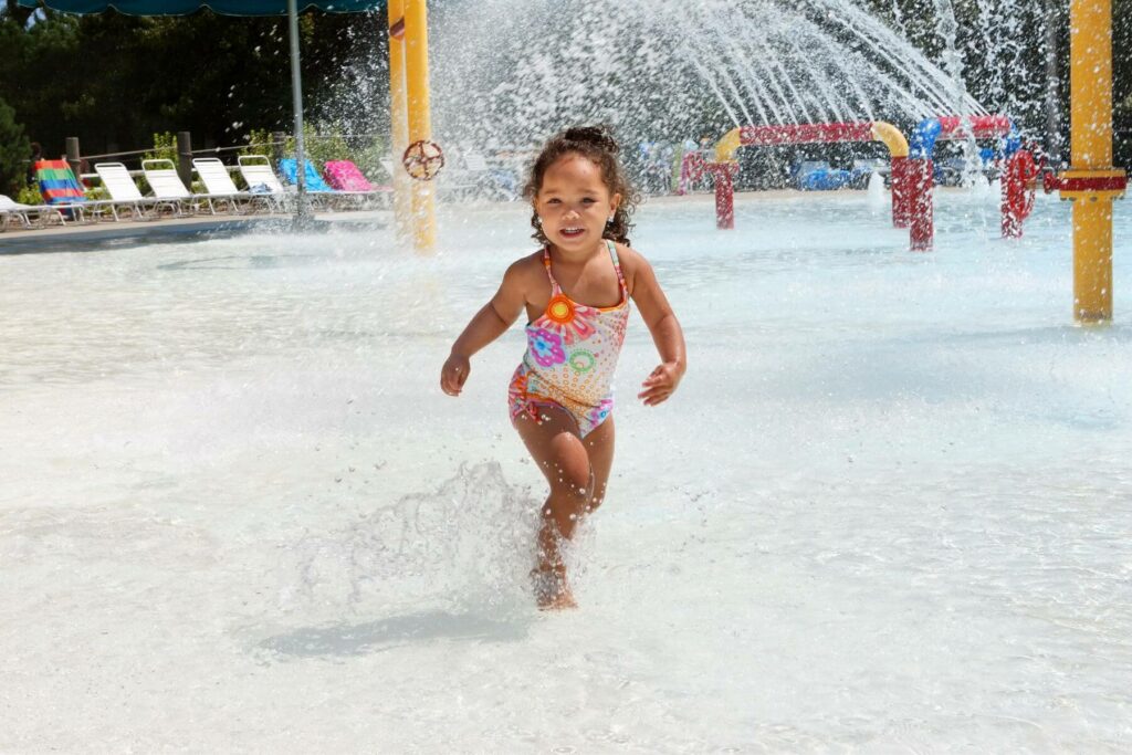a little girl runs through a waterpark