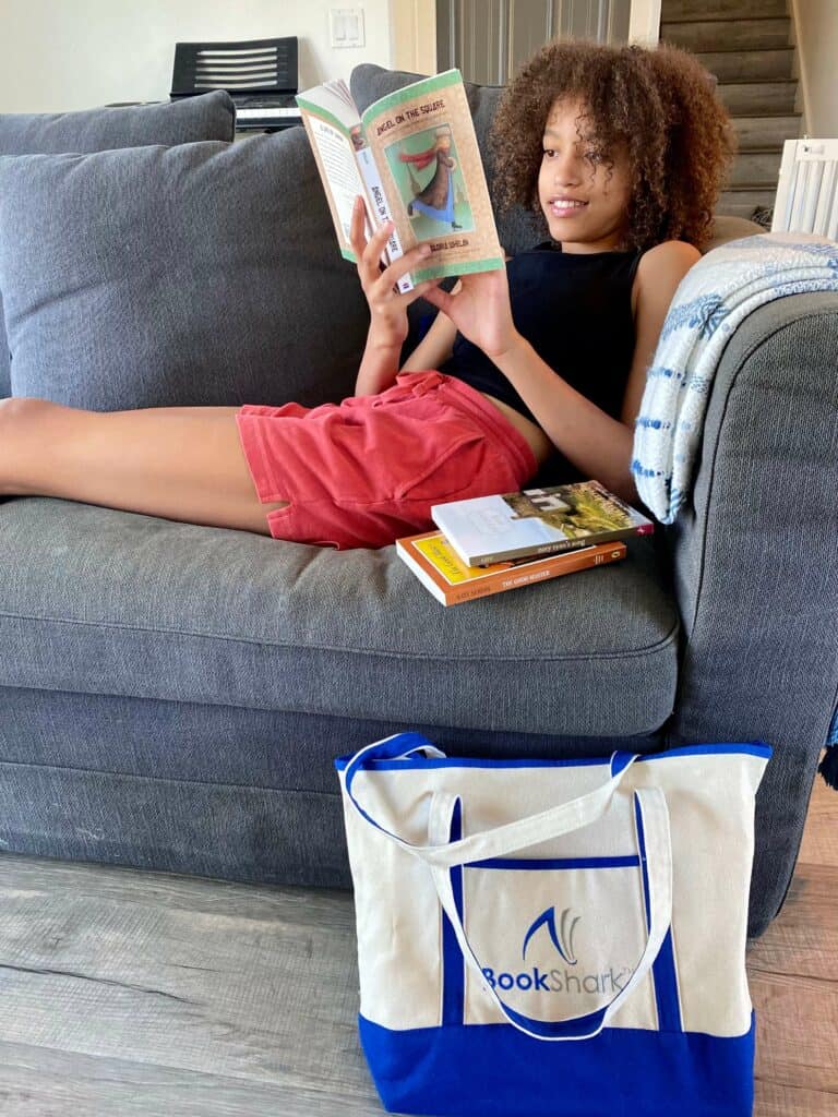 teen sits on couch and reads a novel