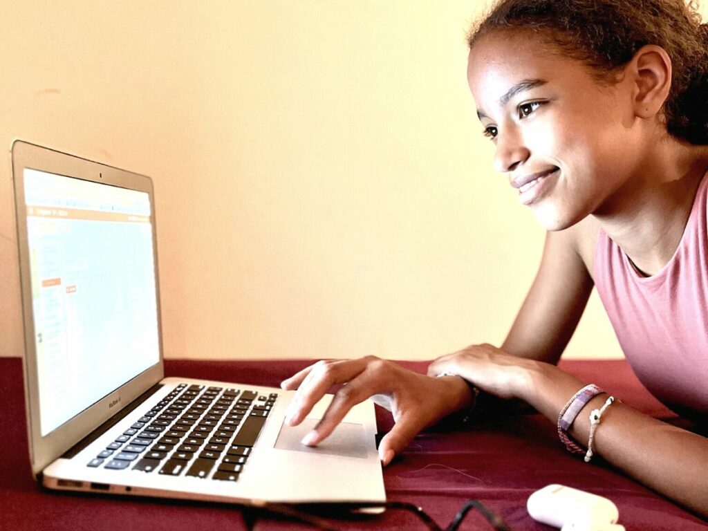 a teen girl works on her homeschool math on a laptop