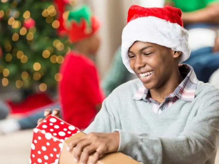 a teen boy opens a Christmas gift
