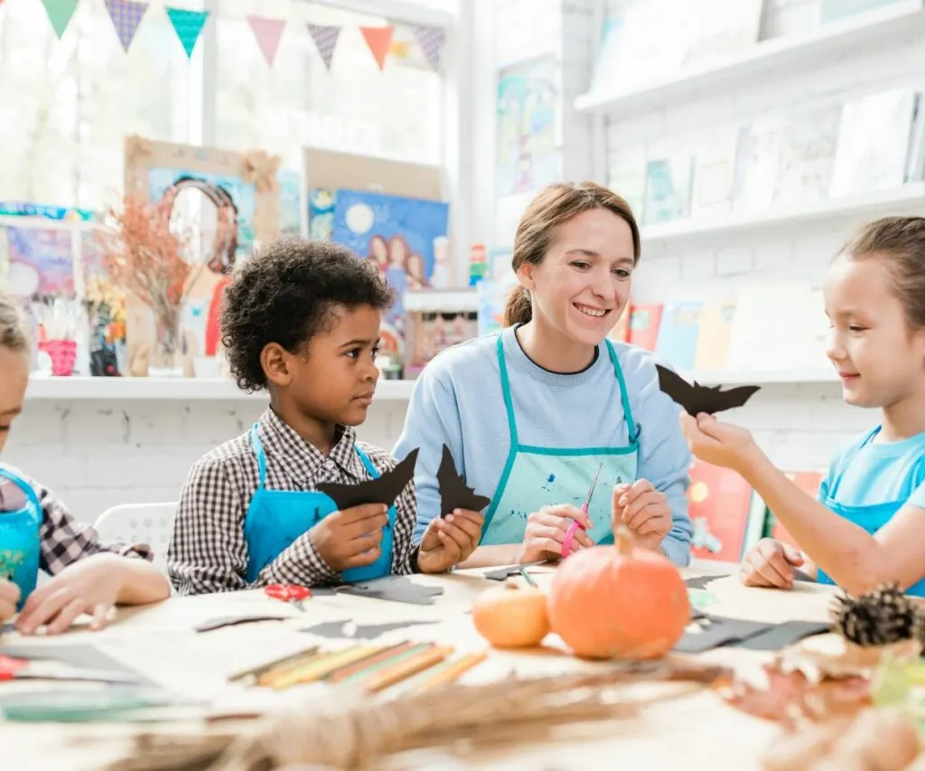 a teacher and her students make Halloween crafts