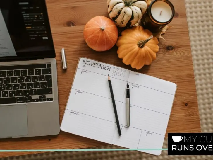 a calendar on a desk with a laptop and some pumpkins